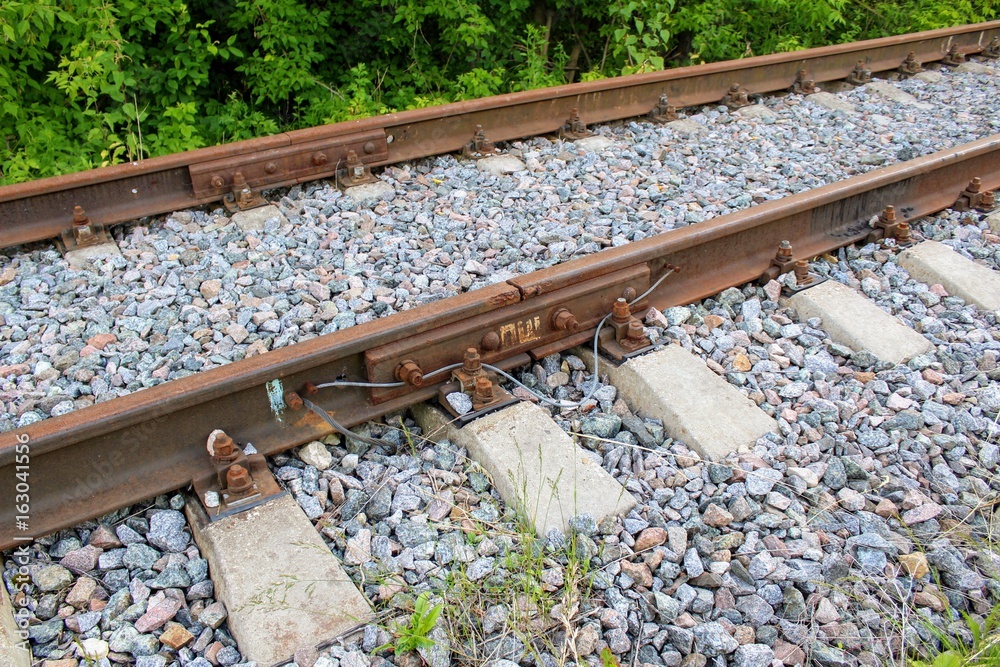 Naklejka premium Rusty track rails. The railway track itself is new, the rails rust from time because there are no trains running through them.