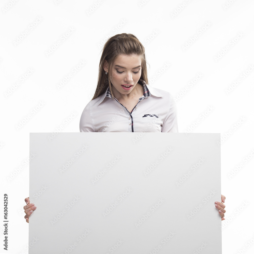 Young curious woman portrait of a confident businesswoman showing presentation, pointing placard gray background. Ideal for banners, registration forms, presentation, landings, presenting concept.. Young curious woman portrait of a confident businesswoman showing presentation, pointing placard gray background. Ideal for banners, registration forms, presentation, landings, presenting concept..