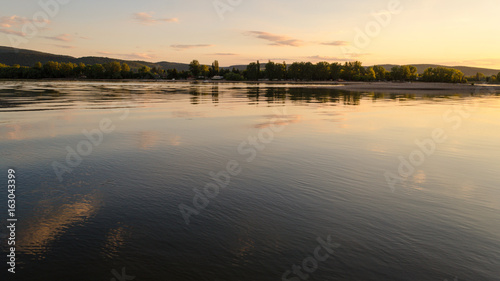summer beach sunset. beauty sunset by river in summertime. reflection of clouds on water in sunset