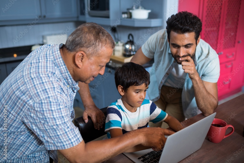 High angle view of father and grandfather looking at boy High angle view of father and grandfather looking at boy
