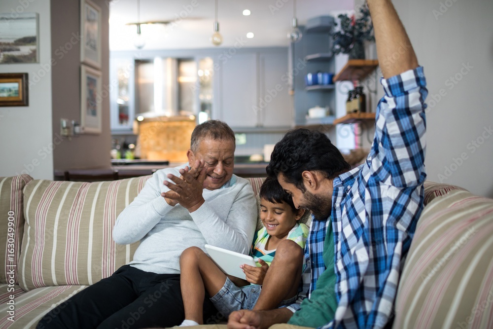 Happy grandfather and father with boy sitting on sofa Happy grandfather and father with boy sitting on sofa