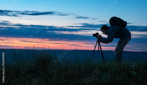Wallpaper Mural Silhouette of a professional photographer using a tripod, taking a photo of a mountain landscape Torontodigital.ca