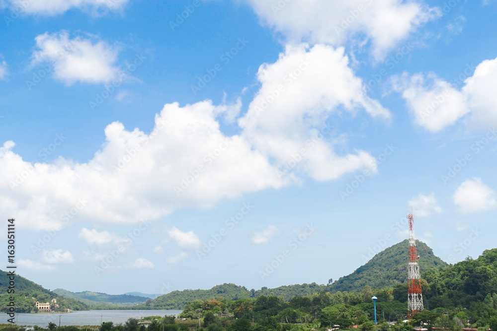 Obraz premium Bright blue sky with mountain view with radio transmission pole or telecommunication tower in a distance.