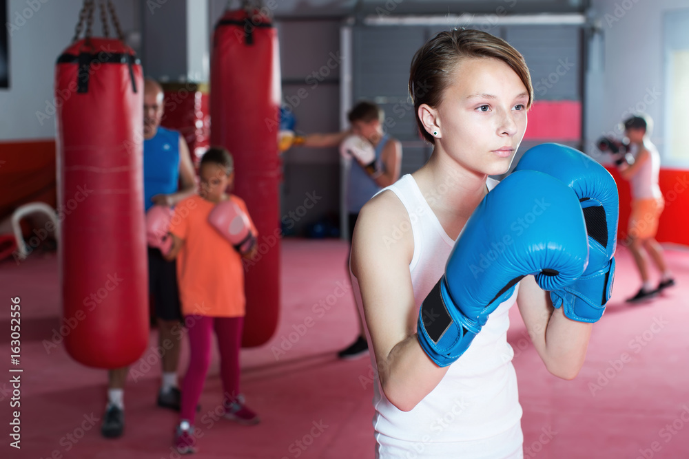 Young serious children with boxing gloves posing
