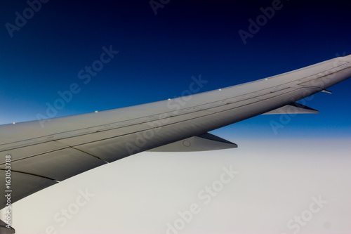 airplane wing above cloud in blue sky