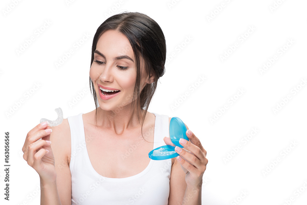 Excited girl is interested in modern orthodontic device Excited girl is interested in modern orthodontic device