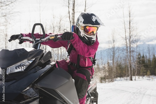 Woman relaxing on snowmobile