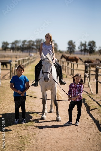 Kids riding a horse in the ranch