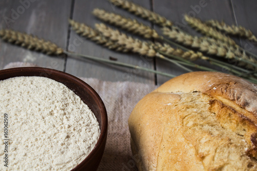 homemade baked bread flour and wheat on light wooden background photo