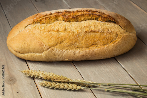 homemade baked bread flour and wheat on light wooden background photo