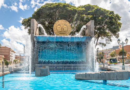 Fotografie Water fountain monument with Golden Inca Sun Disc in the streets of Cusco City -