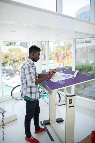 Fotografie Male executive working over drafting table