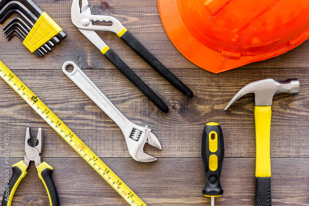 Tools for repairing and helmet on wooden desk background top view Tools for repairing and helmet on wooden desk background top view