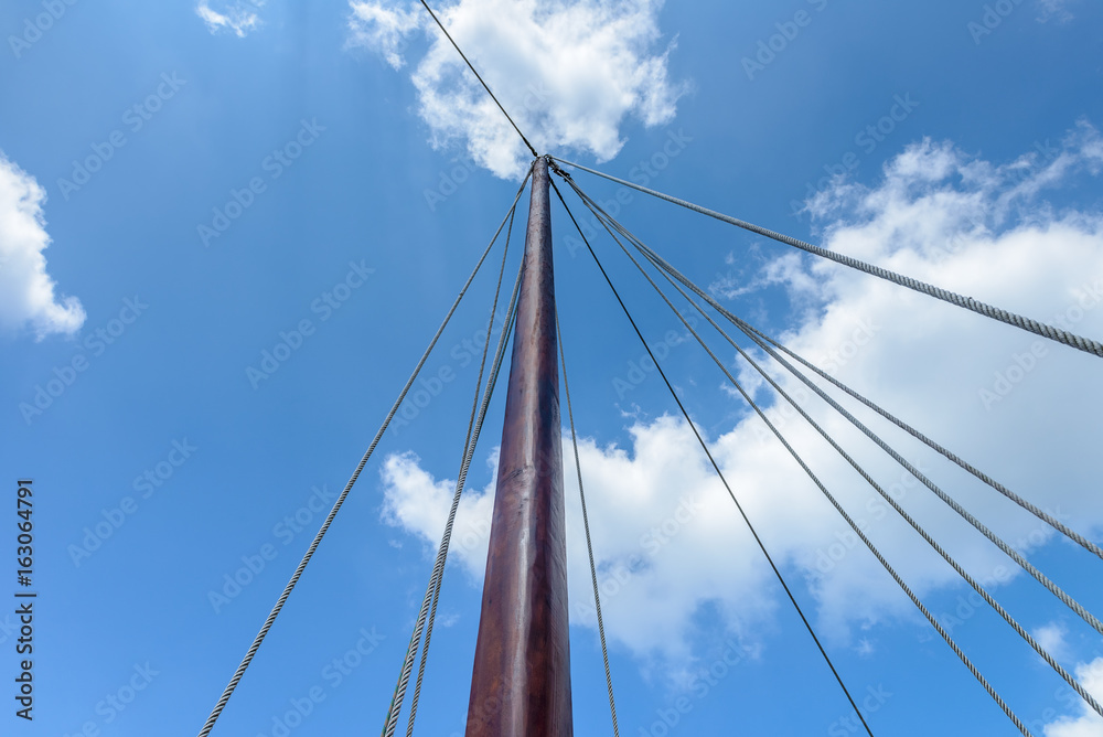wooden sailing mast against the blue sky wooden sailing mast against the blue sky