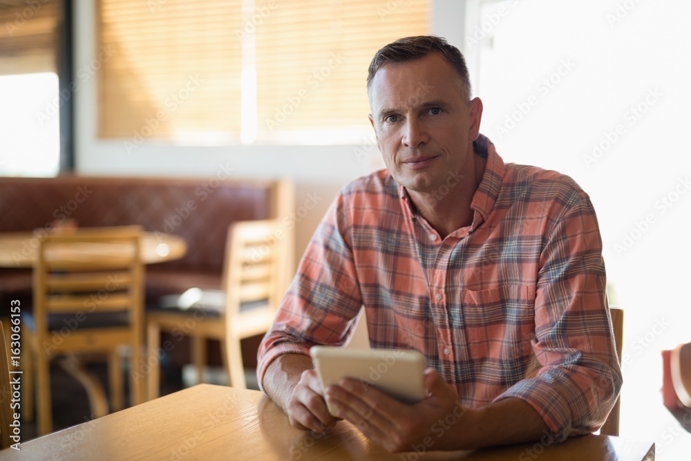 Man using digital tablet in restaurant Man using digital tablet in restaurant