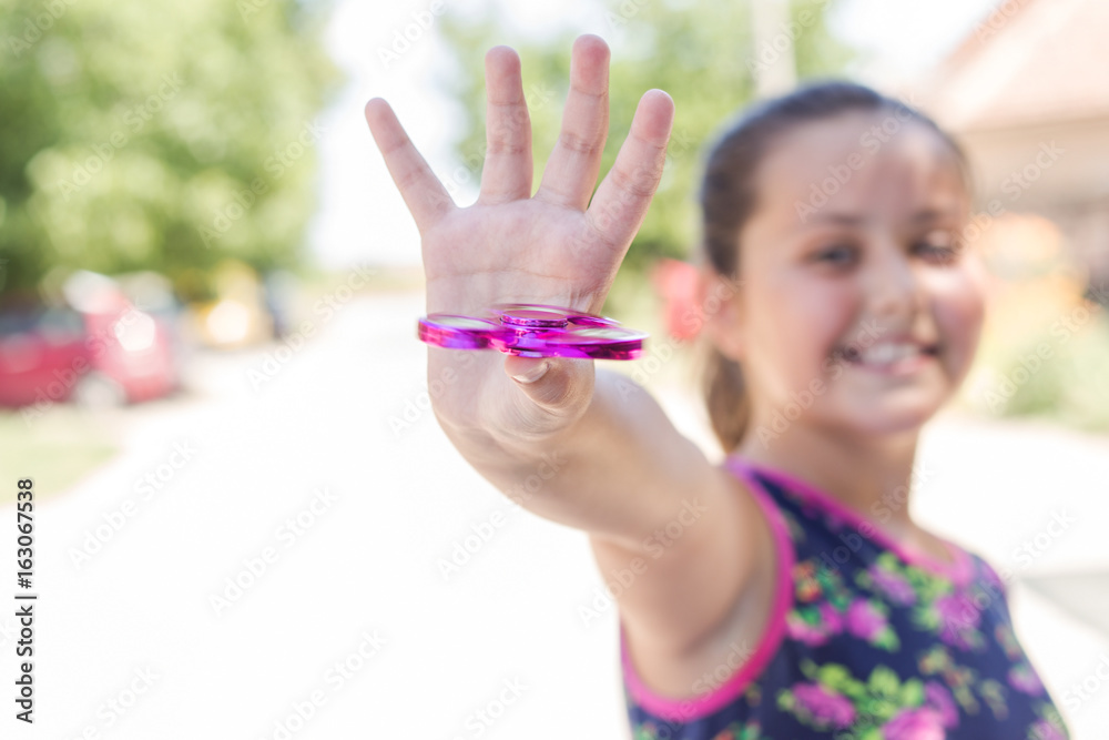 Girl playing with a fidget spinner toy Girl playing with a fidget spinner toy