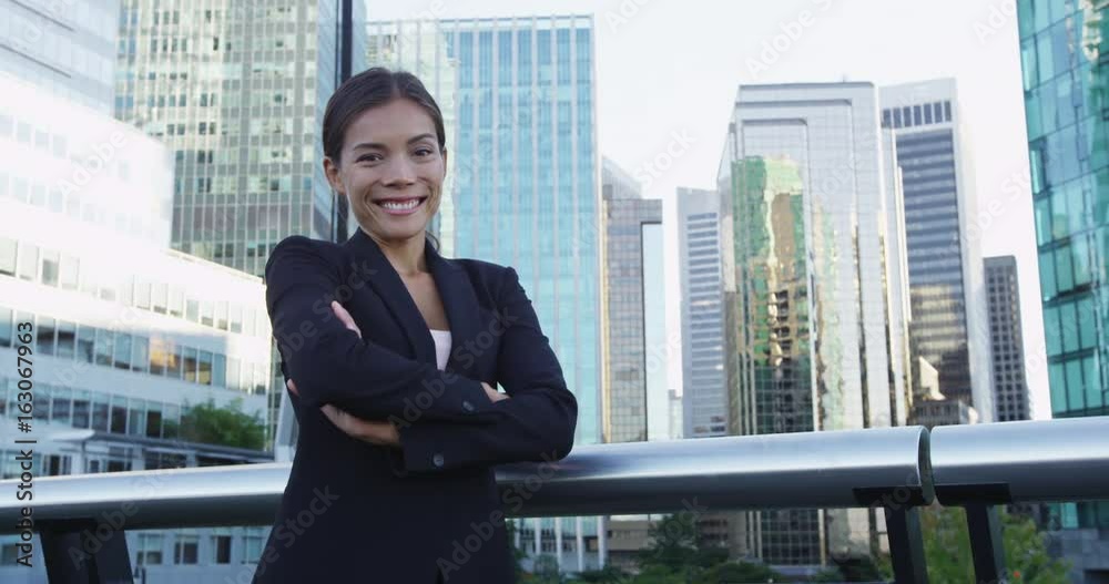 Asian Business woman portrait of young female urban professional businesswoman in suit with arms crossed in Downtown Vancouver, Canada. Confident successful multicultural Asian / Caucasian woman Asian Business woman portrait of young female urban professional businesswoman in suit with arms crossed in Downtown Vancouver, Canada. Confident successful multicultural Asian / Caucasian woman