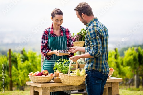 Woman selling organic vegetables to man