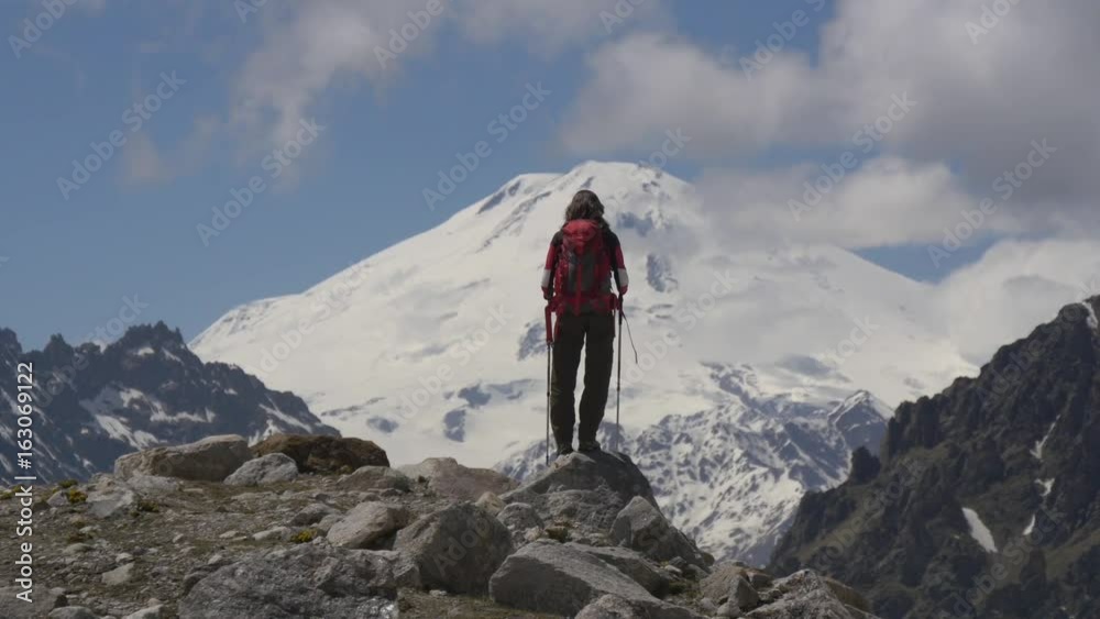 Hiker looking at majestic view of high mountains Hiker looking at majestic view of high mountains