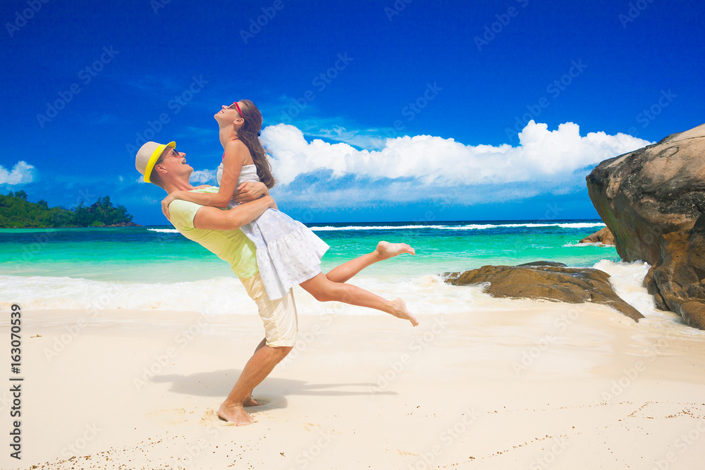 happy young couple hugging at the beach. Seychelles. Mahe Island. Baie Lazare beach happy young couple hugging at the beach. Seychelles. Mahe Island. Baie Lazare beach