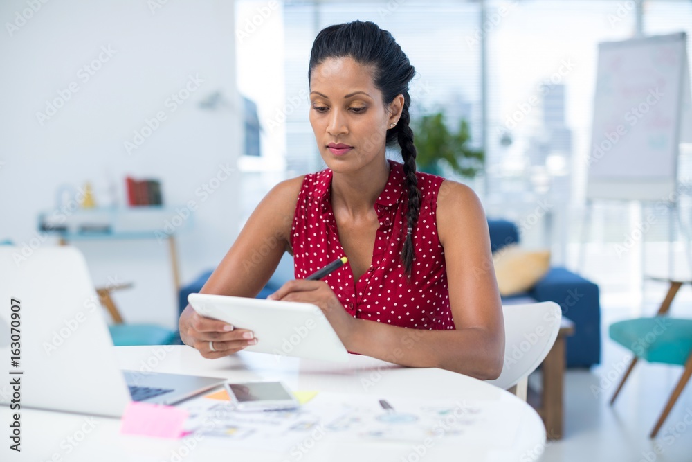 Female graphic designer using graphic tablet at desk Female graphic designer using graphic tablet at desk