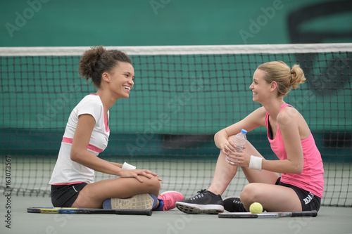 two tennis player relaxing after a training