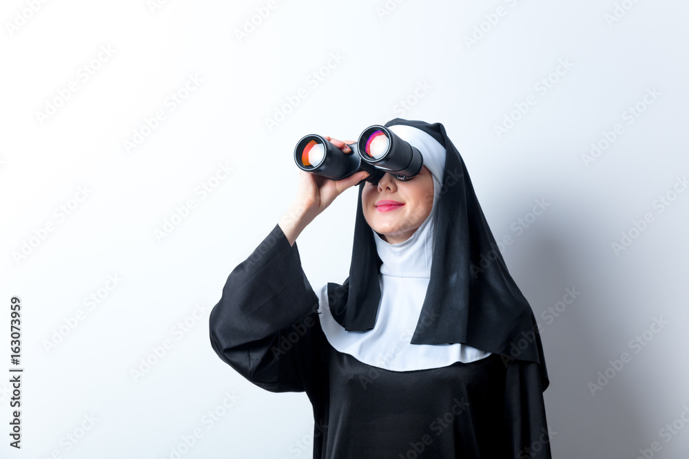 Young smiling nun with binoculars Young smiling nun with binoculars