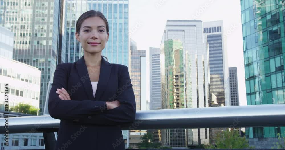 Business woman portrait of young female urban professional businesswoman in suit with arms crossed in Downtown Vancouver, BC, Canada. Confident successful multicultural Chinese Asian / Caucasian woman Business woman portrait of young female urban professional businesswoman in suit with arms crossed in Downtown Vancouver, BC, Canada. Confident successful multicultural Chinese Asian / Caucasian woman