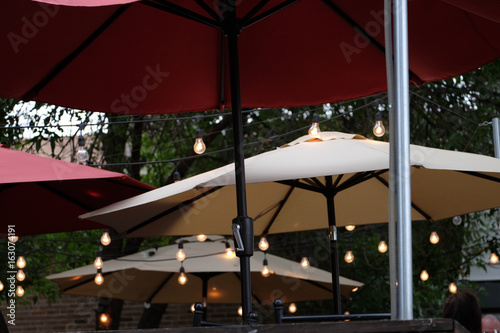 Patio umbrellas outside with lights on