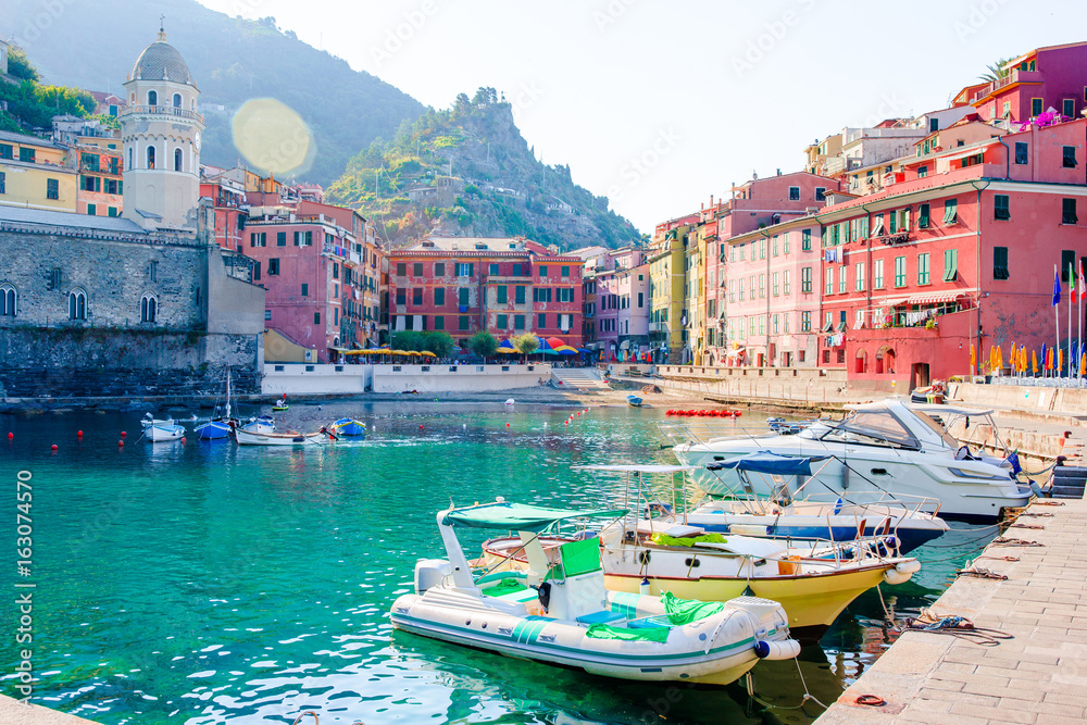 Beautiful cozy bay with boats and clear turquoise water in Italy. View of the old european small village.