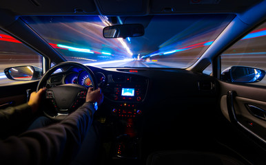 Fotobehang Snelle auto Handen aan stuur tijdens nachtrit  © narozhnii