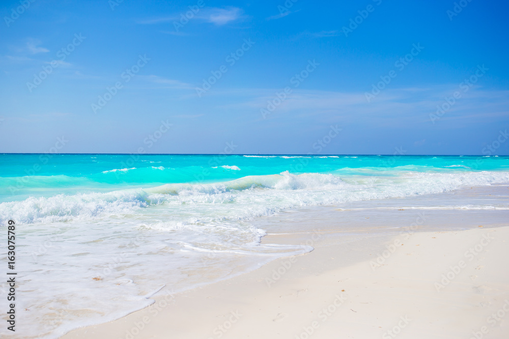 Idyllic tropical beach on Cuba in Caribbean with white sand, turquoise ocean water and blue sky
