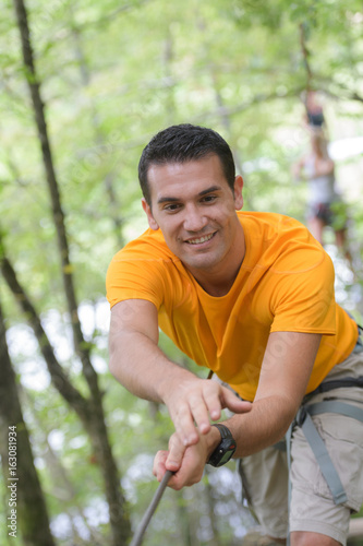 happy man at the extreme rope park with carabiners