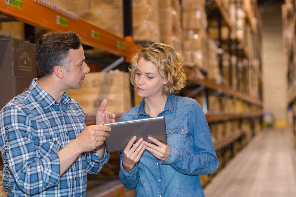 man and woman worker with tablet at warehouse