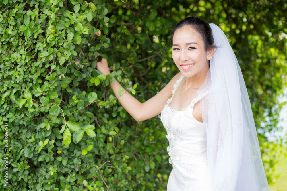 beautiful young woman on wedding day in white dress in the tree wall. Female portrait in the park - Selective focus beautiful young woman on wedding day in white dress in the tree wall. Female portrait in the park - Selective focus