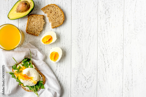 sandwich with poached eggs on wooden background top view mockup