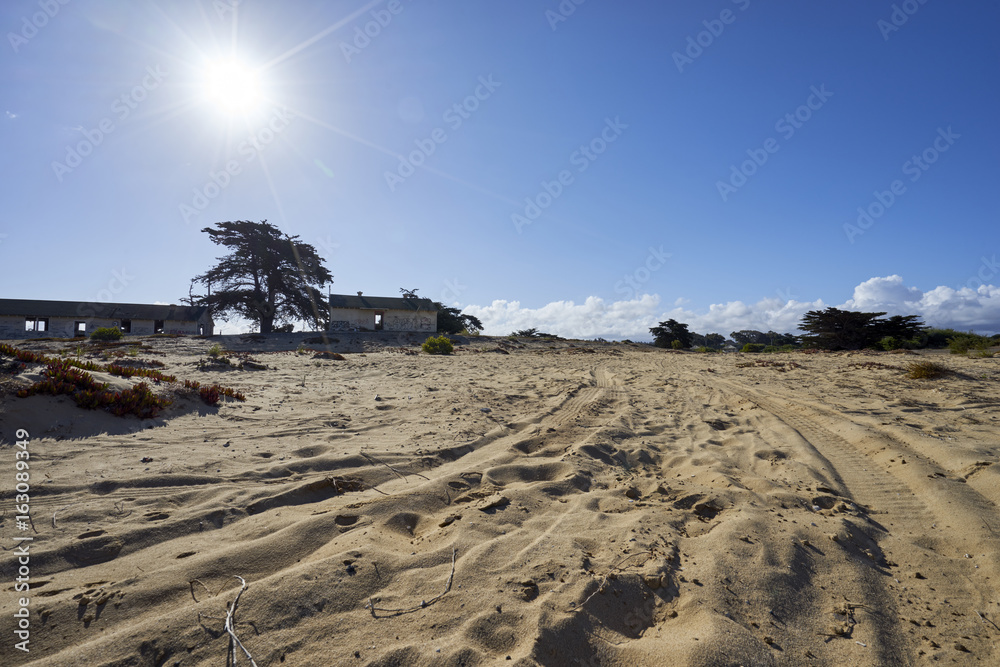 Obraz premium tire tracks through the sand leading to deserted military base