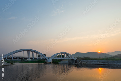 The white bridge backdrop orange sky at the morning in Lamphun. Thailand © pasgen