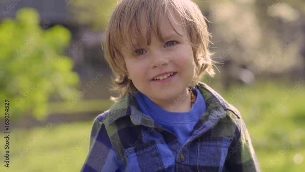 Portrait Of Happy Little Boy Sitting On A Bench In A City Park On A Sunny Day Portrait Of Happy Little Boy Sitting On A Bench In A City Park On A Sunny Day
