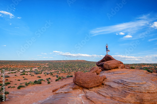 Person Standing Yoga Pose on Top of Rock