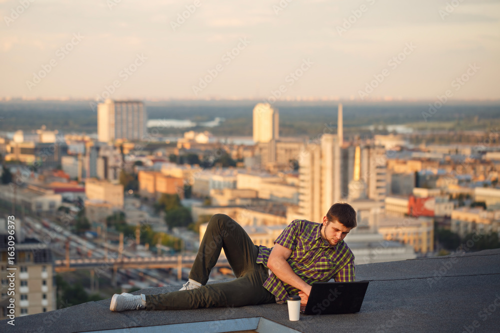 Hipster with laptop on roof Hipster with laptop on roof