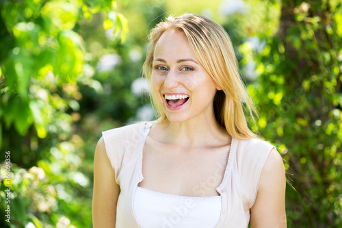 Portrait of glad young blond woman in garden