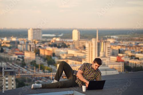 Hipster with laptop on roof