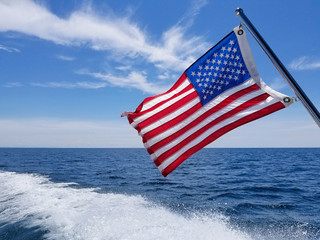 American flag on boat with boating wake on Lake Michigan
