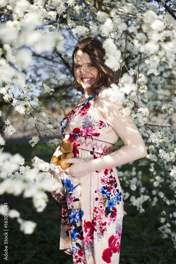 Young beautiful pregnant woman, blooming garden Young beautiful pregnant woman, blooming garden