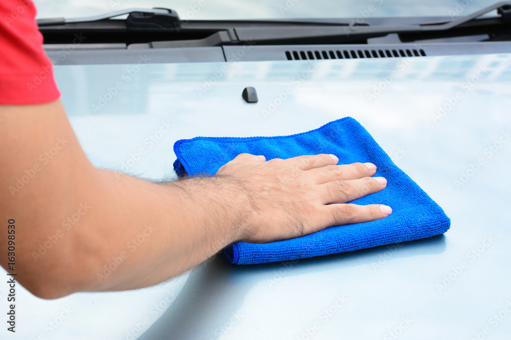 Hand cleaning car bonnet with microfiber cloth
