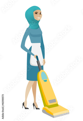 Muslim chambermaid cleaning floor with a vacuum.