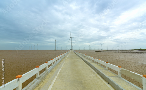Clean energy  wind power plant with a pathway to the giant wind turbines at sea to provide electricity for human life.