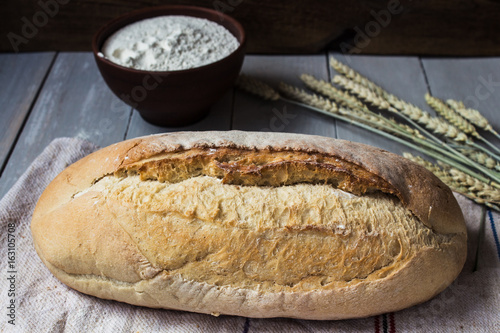 homemade baked bread flour and wheat on light wooden background photo