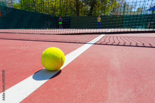 tennis ball on a tennis court with net © fotofabrika